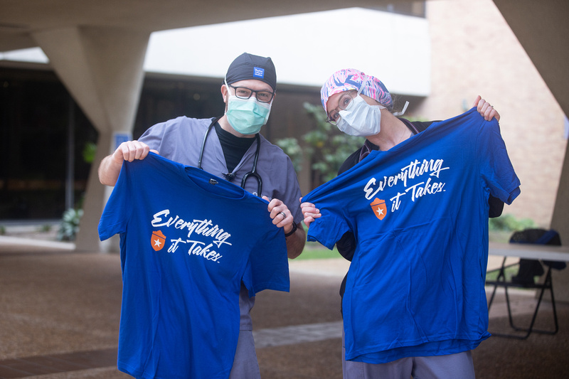 Two doctors holding shirts